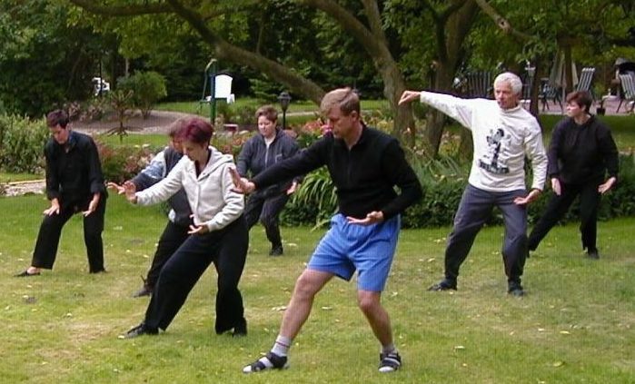Entspannungstraining im Hausgarten große Tai Chi Gruppe im Hausgarten
